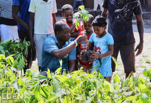 Guy giving seedlings to kids